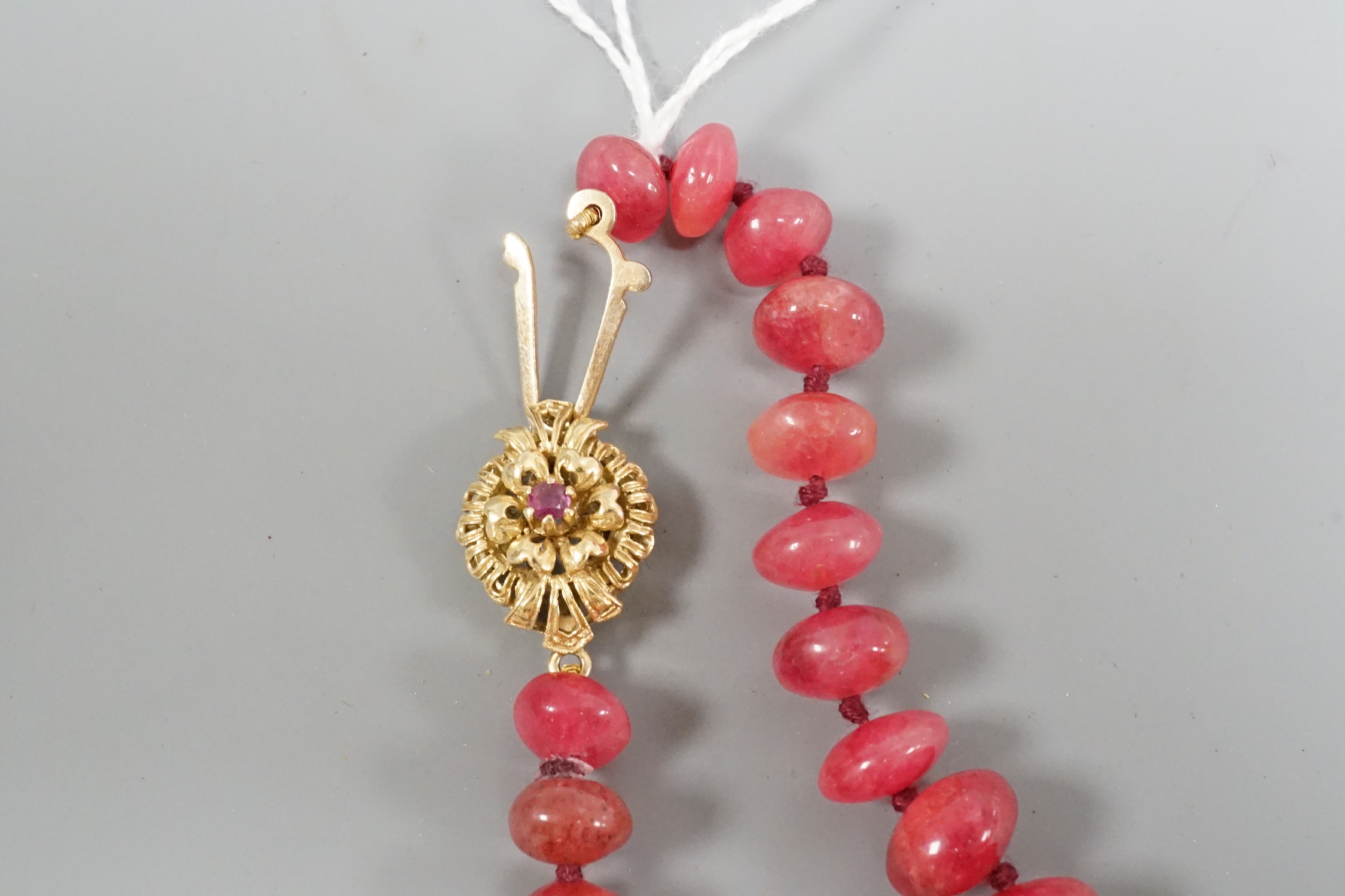 A modern single strand graduated polished ruby pebble necklace, with 585 yellow metal clasp, 54cm.